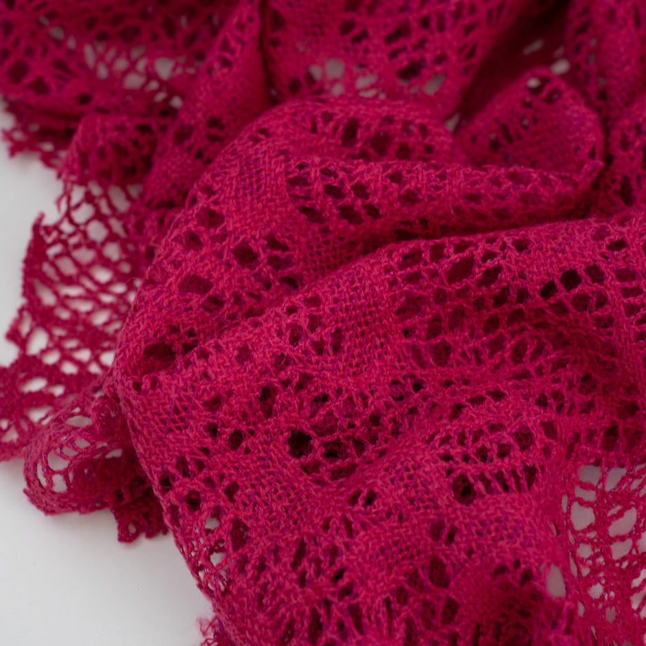 Fucsia lace wool and polyester with a geometric pattern. The fabric is stretch and falling. High-quality deadstock fabric collected in Stock from a Maison de Couture in Italy.