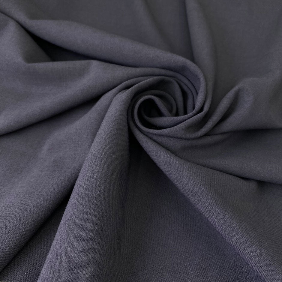 Soft and flowy stretch wool in dark gray. Comfortable and versatile, ideal for trousers, dresses, skirts, and jackets.High-quality deadstock collected in Stock from a Maison de Couture in Italy.