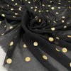 Polyester georgette transparent in black color with cool and gold polka dots, very soft and light. High-quality deadstock fabric collected in Stock from a Maison de Couture in Italy.