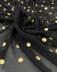 Polyester georgette transparent in black color with cool and gold polka dots, very soft and light. High-quality deadstock fabric collected in Stock from a Maison de Couture in Italy.