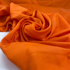 Silk with polyester and viscose in a very bright orange. The fabric is structured. High-quality deadstock fabric collected in Stock from a Maison de Couture in Italy.