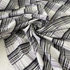 Checked fabric in a wool and cotton blend with a taffeta-like texture that keeps its shape and adds volume. In shades of white, black, and lilac. Ideal for dresses, skirts, and shirting. High-quality deadstock collected in Stock from a Maison de Couture in Italy.