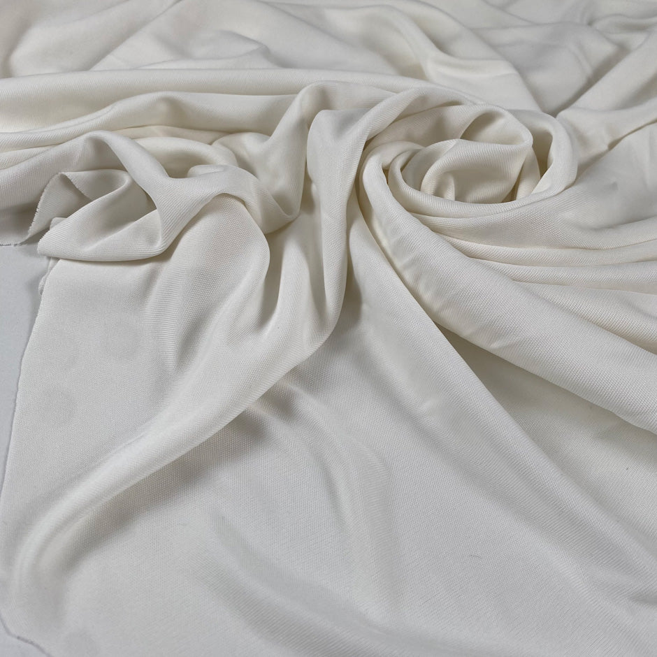 Viscose jersey with stretch in white color reference Snow White. Very soft and flowy, slightly shiny and not transparent. Ideal for dresses, linings, trousers, skirts, blouses and shirting. High-quality deadstock collected in Stock from a Maison de Couture in Italy.