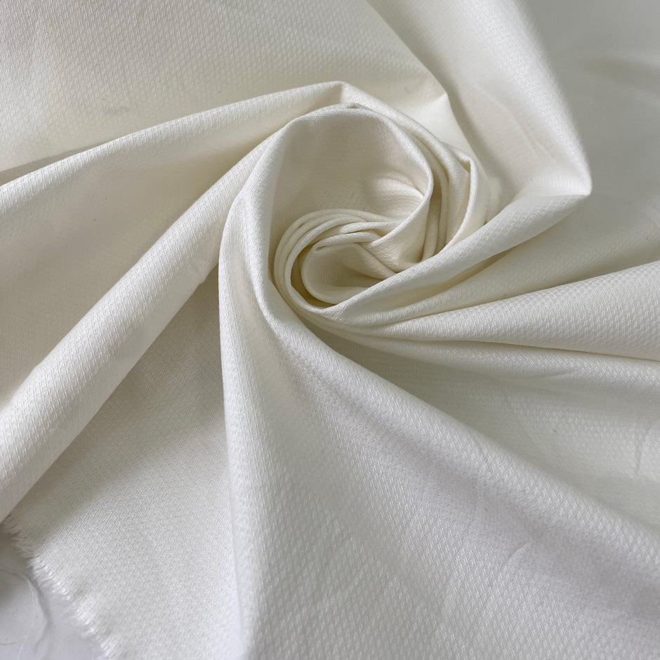 Stretch cotton piquet with texture in white color reference Sugar Swizzle. Very soft with low stretch. Ideal for trousers, dresses, skirts and jackets. High-quality deadstock collected in Stock from a Maison de Couture in Italy.