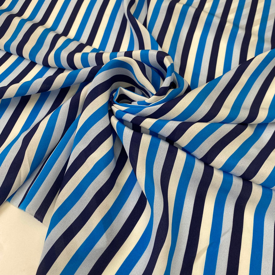 Pure silk crêpe de chine with stripe design in the shades of white, dark blue, light blue and turquoise. Very soft and light, flowy and not transparent. Ideal for dresses, skirts, blouses, and shirting. High-quality deadstock collected in Stock from a Maison de Couture in Italy.