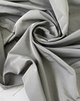 Polyester and silk taffeta in gray color reference drizzle. Stiff and voluminous, ideal for shirting, dresses, skirts, and jackets. High-quality deadstock collected in Stock from a Maison de Couture in Italy.