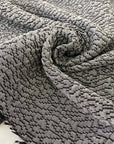 Jacquard fabric in gray with textured surface. A soft and heavy mix of polyester, viscose, and wool, ideal for light coats, jackets, dresses, and skirts. High-quality deadstock collected in Stock from a Maison de Couture in Italy.