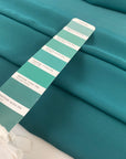 Polyester georgette in green color reference Bayou. Very soft, light, and transparent. Ideal for dresses, skirts, blouses, and shirting. High-quality deadstock collected in Stock from a Maison de Couture in Italy.