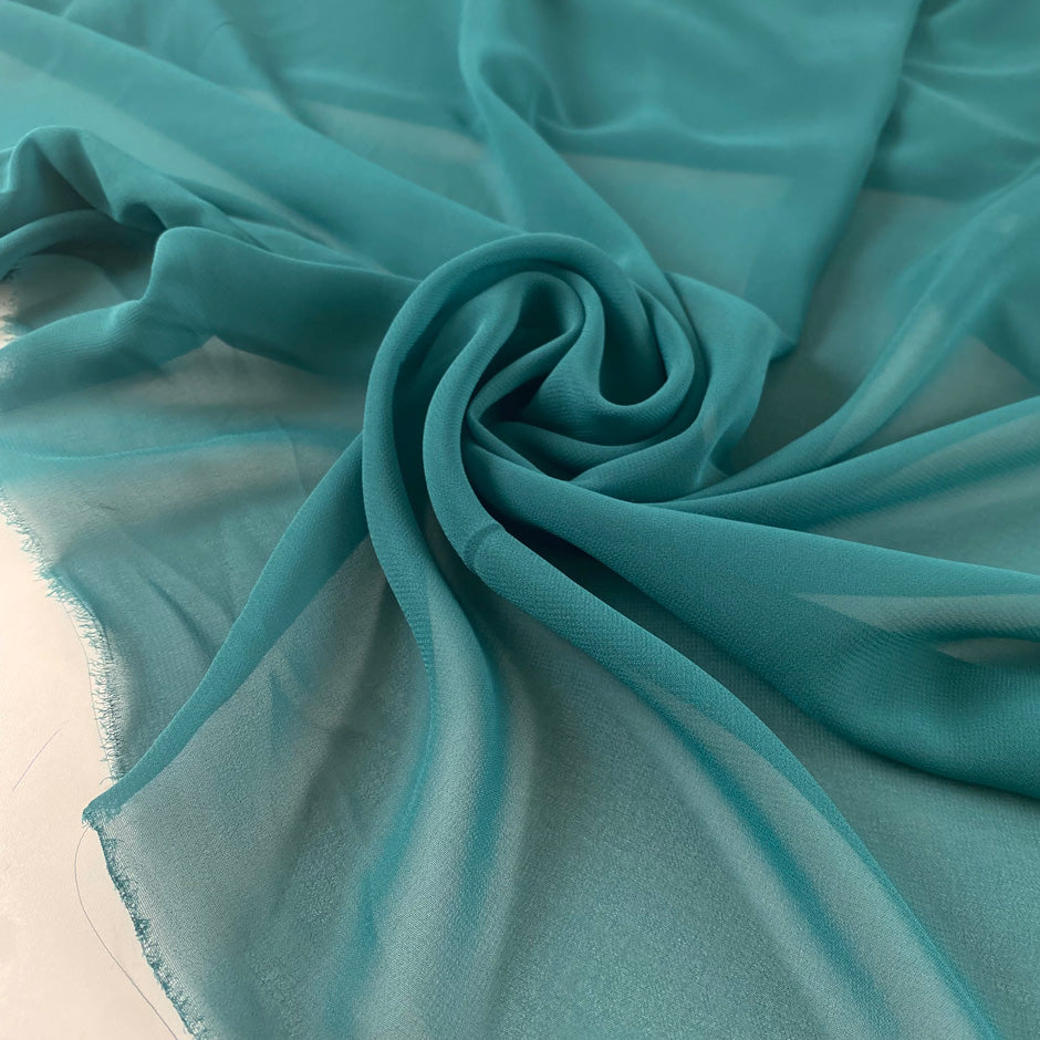 Polyester georgette in green color reference Bayou. Very soft, light, and transparent. Ideal for dresses, skirts, blouses, and shirting. High-quality deadstock collected in Stock from a Maison de Couture in Italy.