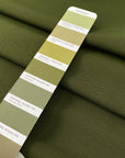 Dark green stretch Punto Milano jersey in polyester and elastane in the shade avocado, slightly heavy and stiff, with a rough texture. Ideal for trousers, skirts, dresses and jackets. High-quality deadstock collected in Stock from a Maison de Couture in Italy.