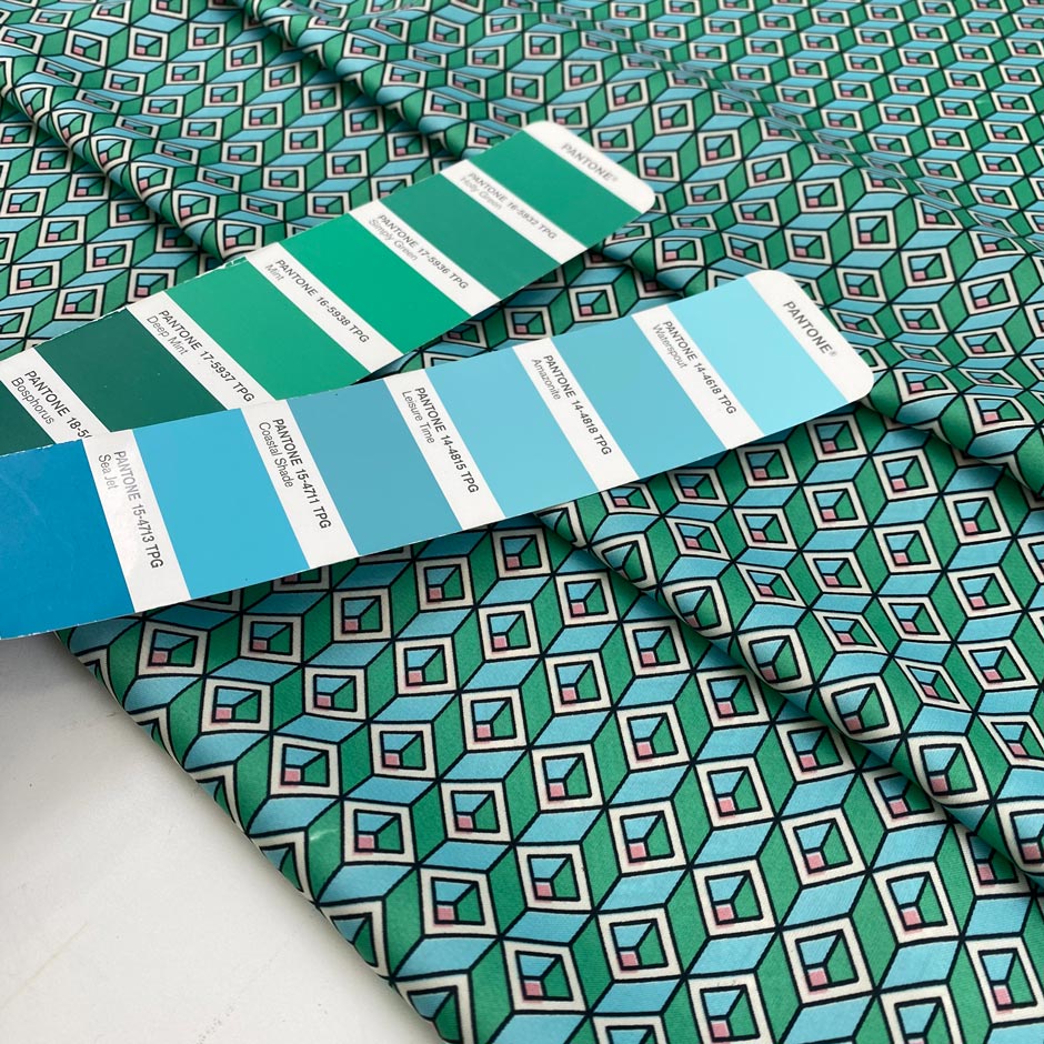 Very soft, smooth, and light polyester satin with a small geometric design in shades of light blue, green, and pink. Not transparent. High-quality deadstock collected in Stock from a Maison de Couture in Italy.