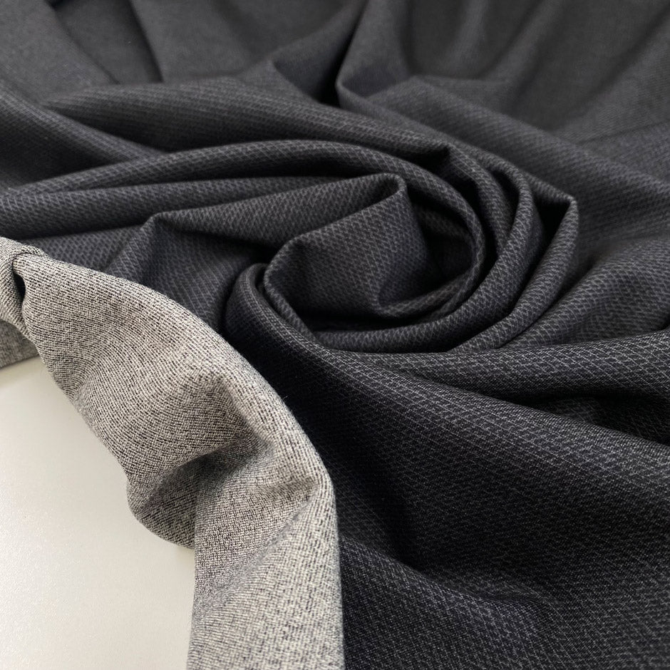 Double-face polyester and elastane fabric with dark grey front and light grey back, very soft and medium weight, ideal for reversible garments, jackets, and dresses. High-quality deadstock collected in Stock from a Maison de Couture in Italy. 