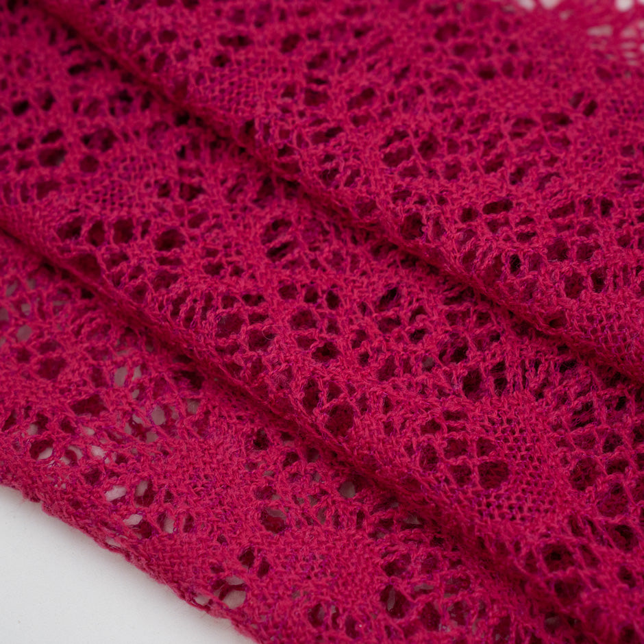 Fucsia lace wool and polyester with a geometric pattern. The fabric is stretch and falling. High-quality deadstock fabric collected in Stock from a Maison de Couture in Italy.