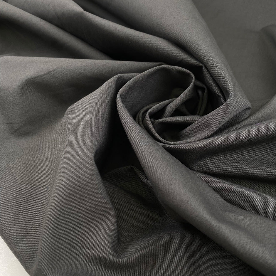 Pure cotton fabric in smoked pearl gray, with a crunchy hand and stiff structure, ideal for sculptural pieces, shirts, and outerwear. High-quality deadstock collected in Stock from a Maison de Couture in Italy.