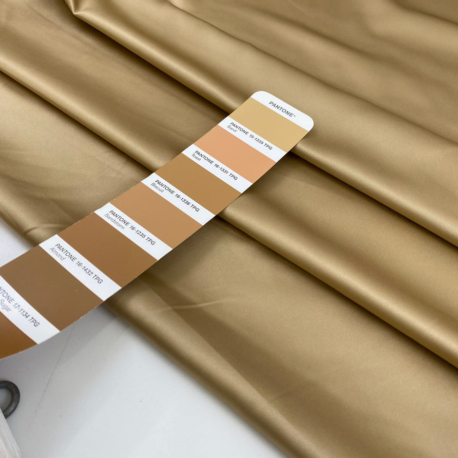 Polyester satin in beige sand very soft and shiny, not transparent and flowy. High-quality deadstock fabric collected in Stock from a Maison de Couture in Italy.