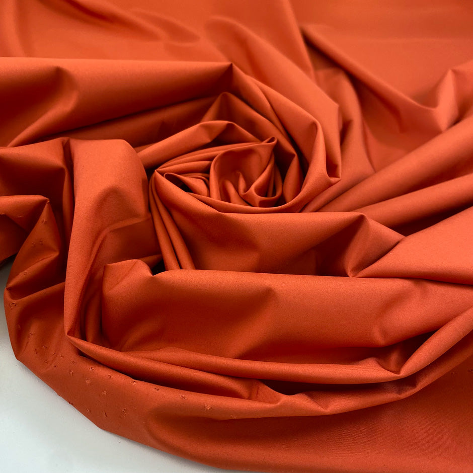 Light and soft waterproof polyester cinzato with elastane in orange, ideal for windbreakers, trenches, and light outerwear. High-quality deadstock collected in Stock from a Maison de Couture in Italy.&nbsp;