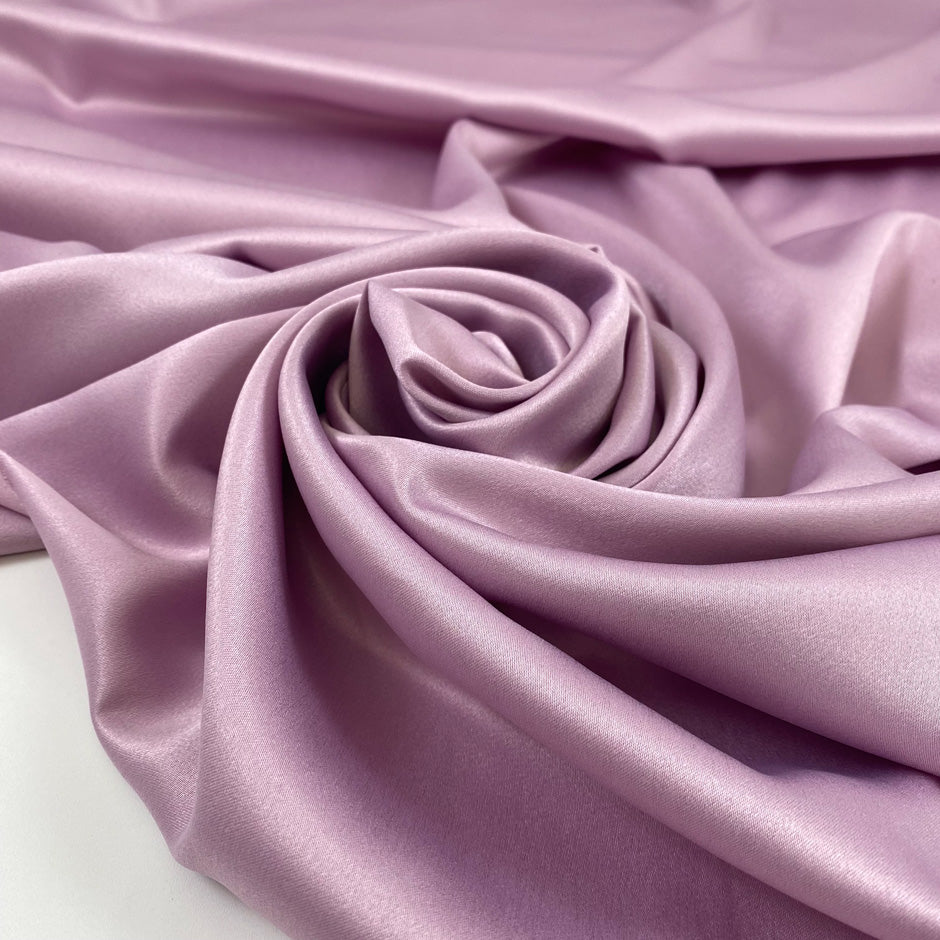 Lilac matte polyester satin with a soft hand and elegant drape, perfect for dresses, linings, and fluid pieces. High-quality deadstock collected in Stock from a Maison de Couture in Italy.