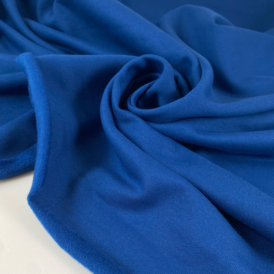 Warm cotton sweatshirt fabric in galaxy blue, very soft and medium weight. Ideal for trousers, sweatshirts, and jackets. High-quality deadstock collected in Stock from a Maison de Couture in Italy.