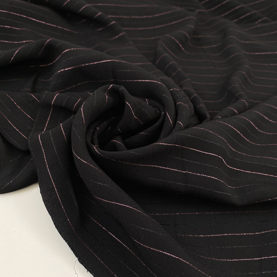 Pure viscose crepe in black with stripe design in rose lurex, very soft, flowy and not transparent. High-quality deadstock fabric by the meter collected in Stock from a Maison de Couture in Italy.
