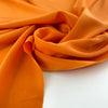 Flowing and falling orange silk crepe de chine fabric. High quality deadstock fabric picked up in Stock from a Maison de Couture in Italy.