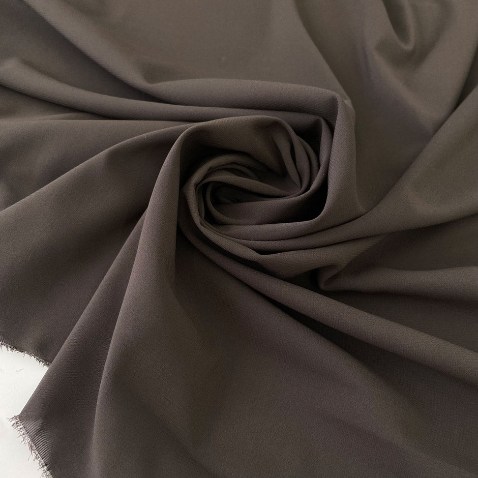 Dark brown polyester crepe, soft and fluid . Perfect dresses, skirts, blouses and shirts. High-quality deadstock collected in Stock from a Maison de Couture in Italy.
