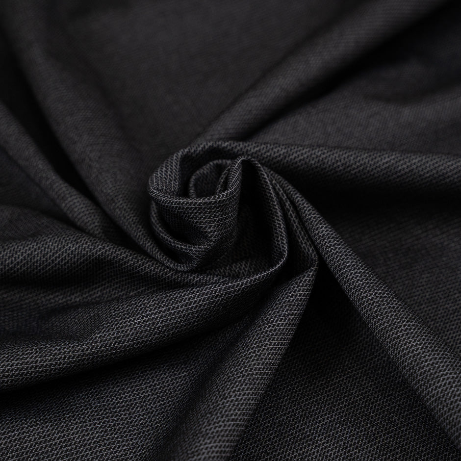 Black worked jersey polyester punto Milano double face. The fabric is stretched and has a black micro drawing. High-quality deadstock collected in Stock from a Maison de Couture in Italy.