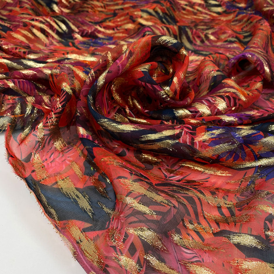 Silk chiffon printed with tropical leaf design in the shades of bright red, blue and violet. With gold lured brushstrokes. Light, soft and transparent. High-quality deadstock fabric collected in Stock from a Maison de Couture in Italy.