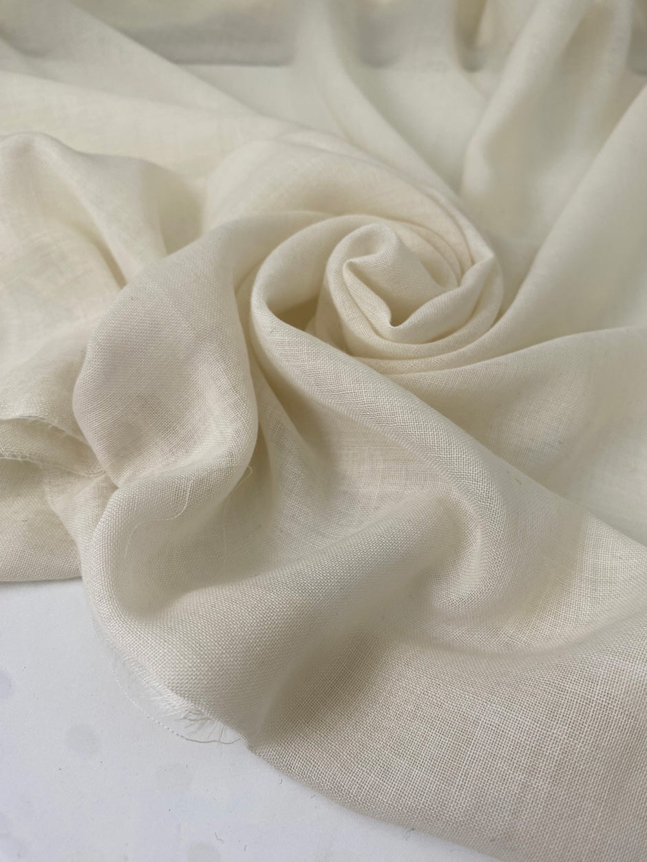 Pure wool muslin in light vanilla color reference Winter White. Very soft, light, and warm, with slight transparency. Flowy and ideal for scarves, light shirting, and dresses. High-quality deadstock collected in Stock from a Maison de Couture in Italy.