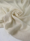 Pure wool muslin in light vanilla color reference Winter White. Very soft, light, and warm, with slight transparency. Flowy and ideal for scarves, light shirting, and dresses. High-quality deadstock collected in Stock from a Maison de Couture in Italy.