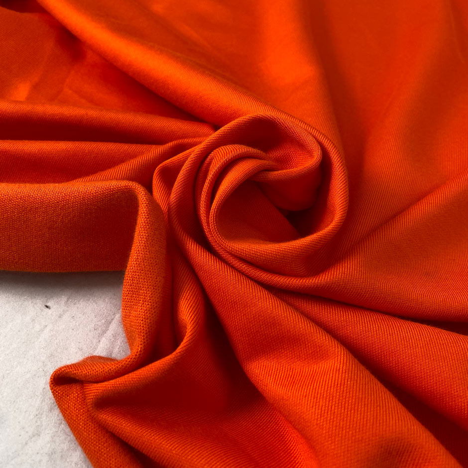 Orange cotton and viscose technical piquet jersey in cherry tomato shade soft stretchy and fluid. Ideal for sweatshirts, trousers, skirts and jackets. High-quality deadstock collected in Stock from a Maison de Couture in Italy.