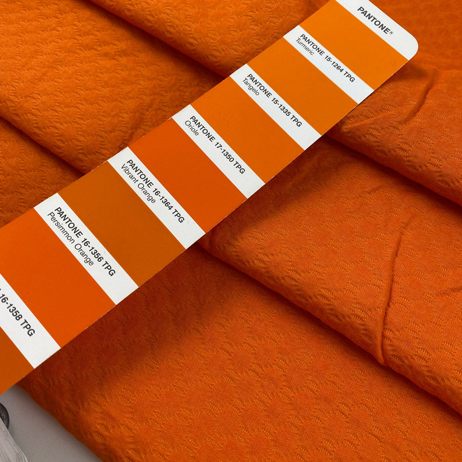 Pure cotton jacquard in vibrant orange, color reference Shakar. Very soft, flowy, and not transparent. Ideal for jackets, dresses, trousers, and skirts. High-quality deadstock collected in Stock from a Maison de Couture in Italy.