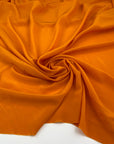 Soft and droopy silk crepe de chine in orange. High-quality fabric deadstock