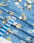 Light blue twill polyester in white and yellow floral design. The fabric is shiny and falling. High-quality deadstock fabric collected in Stock from a Maison de Couture in Italy.