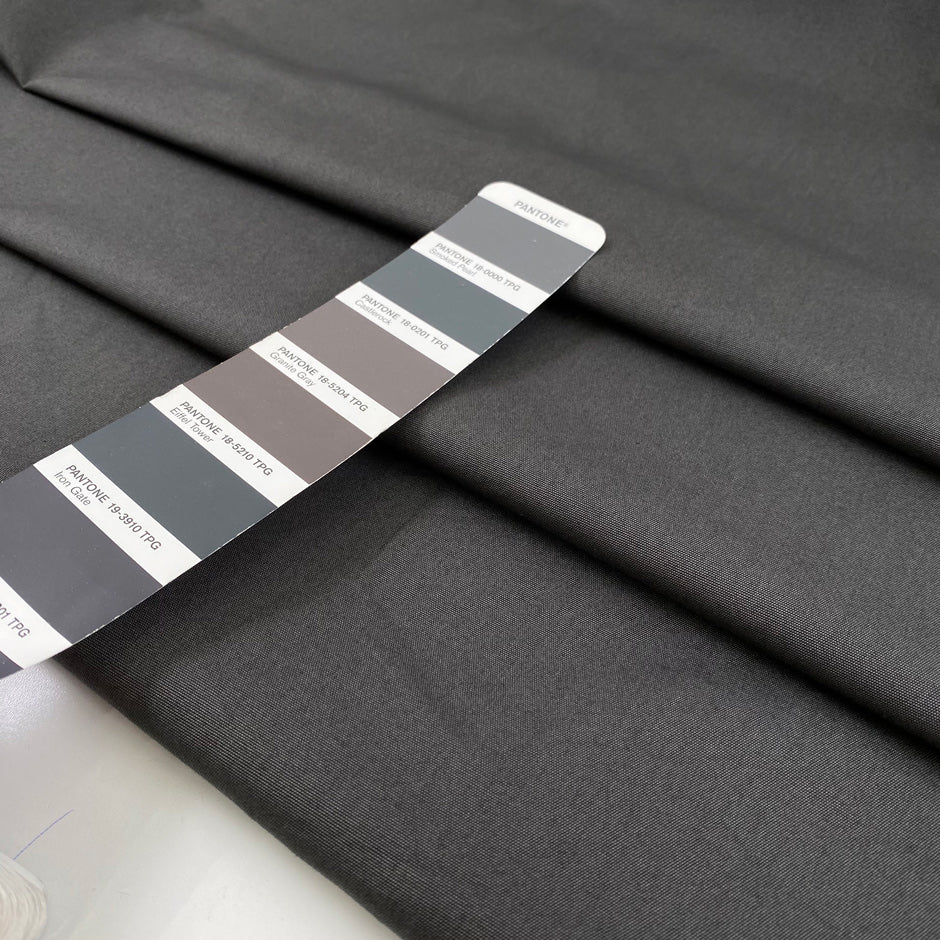Pure cotton fabric in smoked pearl gray, with a crunchy hand and stiff structure, ideal for sculptural pieces, shirts, and outerwear. High-quality deadstock collected in Stock from a Maison de Couture in Italy.