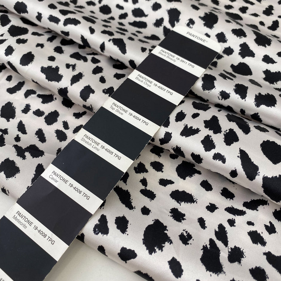 Polyester satin with stretch in black and white animal print. Shiny, very soft and light, flowy and not transparent. Ideal for dresses, skirts, blouses, and shirting. High-quality deadstock collected in Stock from a Maison de Couture in Italy.
