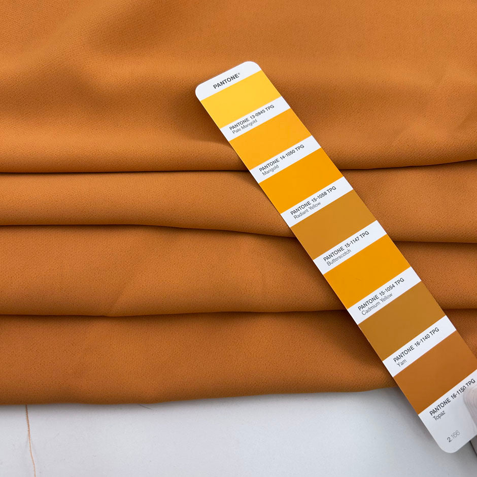 Dark yellow viscose cady crepe fabric with a soft hand, non-stretch constructionand not transparent. Ideal for creating trousers. High-quality deadstock collected in Stock from a Maison de Couture in Italy.