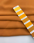 Dark yellow viscose cady crepe fabric with a soft hand, non-stretch constructionand not transparent. Ideal for creating trousers. High-quality deadstock collected in Stock from a Maison de Couture in Italy.