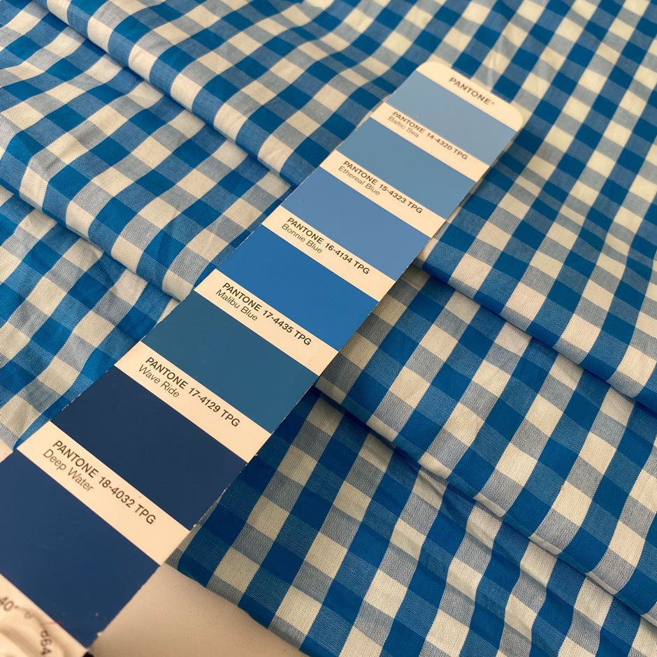 Pure cotton poplin with a small check design, approximately one centimeter squares, in light blue color reference Bu Blue. Very soft, light, flowy, and not transparent. Ideal for shirting, dresses, and skirts. High-quality deadstock collected in Stock from a Maison de Couture in Italy.