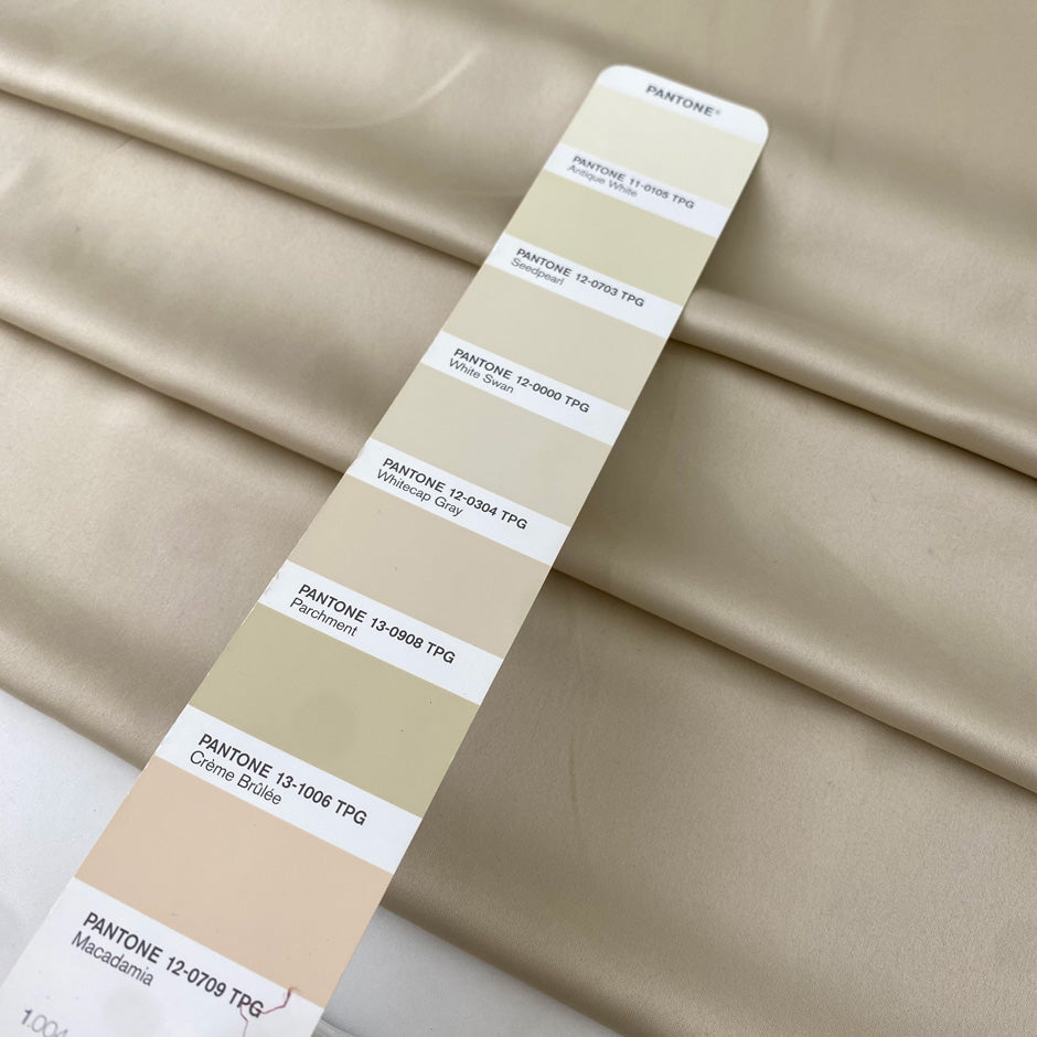 Polyester satin in cream color. Very soft, light, and flowy. Not transparent. Ideal for dresses, skirts, blouses, and shirting. High-quality deadstock collected in Stock from a Maison de Couture in Italy.