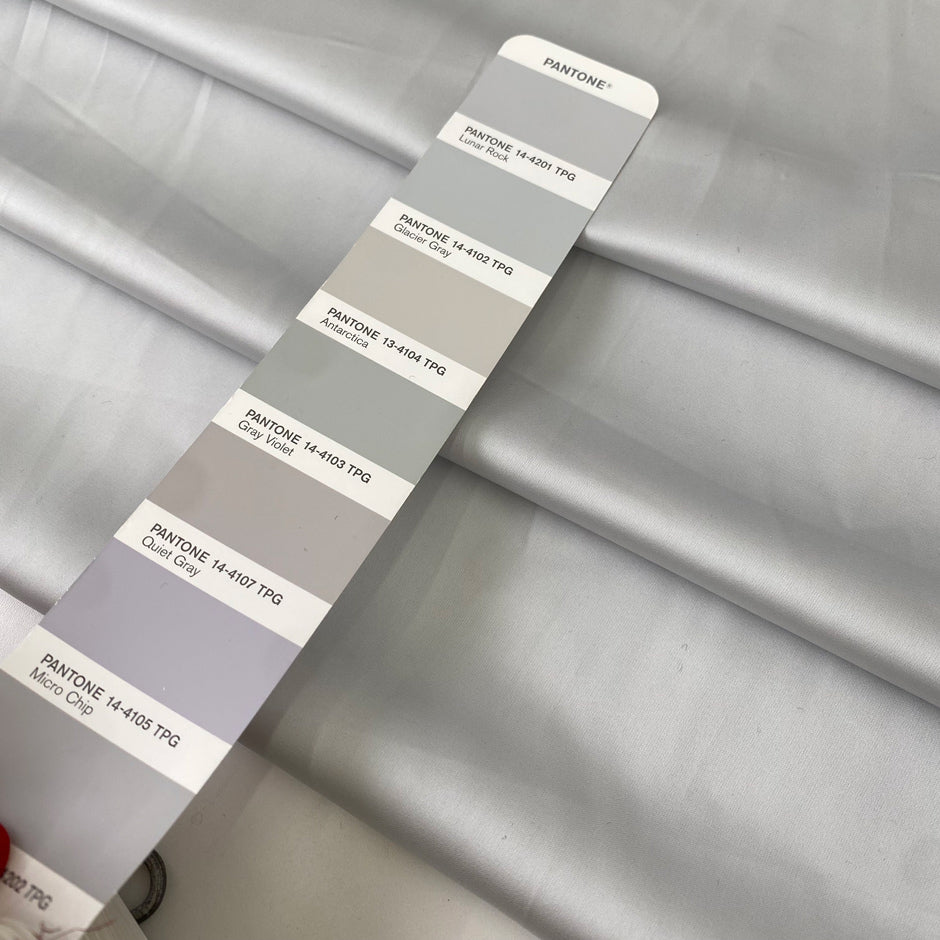 Polyester satin in light gray, Glacier Gray. Very soft, light, shiny and flowy, not transparent. Ideal for dresses, skirts, blouses, and shirting. High-quality deadstock collected in Stock from a Maison de Couture in Italy.