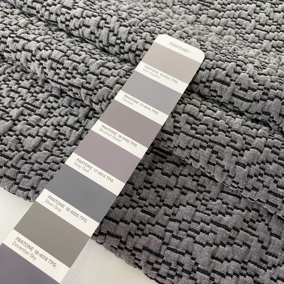 Jacquard fabric in gray with textured surface. A soft and heavy mix of polyester, viscose, and wool, ideal for light coats, jackets, dresses, and skirts. High-quality deadstock collected in Stock from a Maison de Couture in Italy.