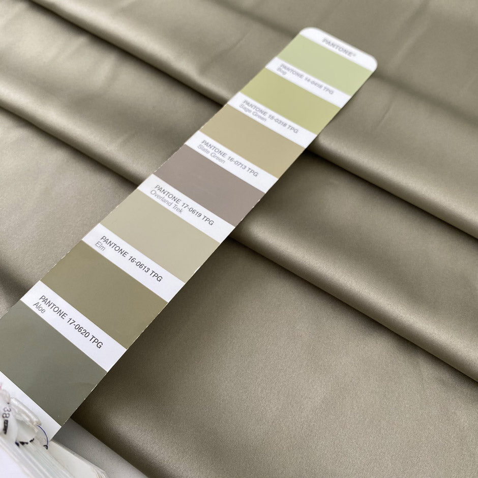 Polyester satin in sage green color reference elm. Very soft, light, and flowy with a matte finish. Not transparent. Ideal for dresses, skirts, and shirting. High-quality deadstock collected in Stock from a Maison de Couture in Italy.