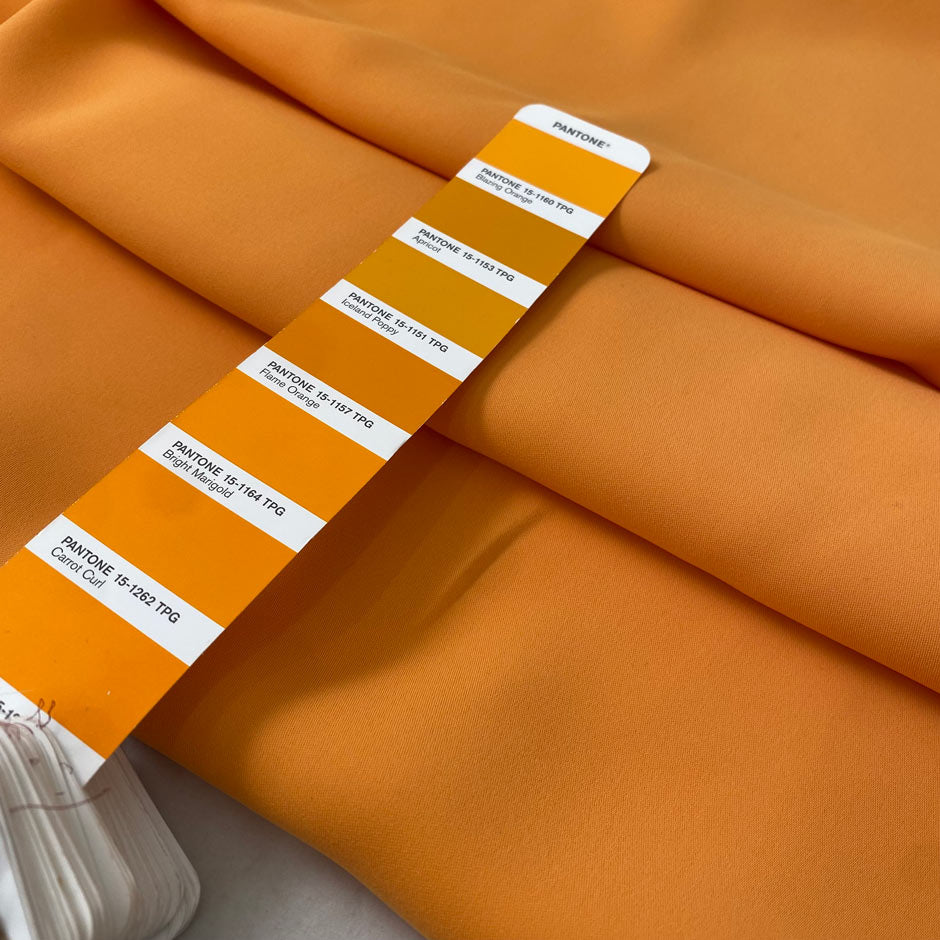 Medium-weight polyester cady in Iceland orange. Puffy, very soft and flowy, not transparent. Ideal for trousers, skirts, dresses, and heavy blouses. High-quality deadstock collected in Stock from a Maison de Couture in Italy.