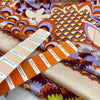 Printed polyester twill in panels. The ground is light peach and the print is in shades of bright orange, lilac, and green. Very flowy, a little shiny. &nbsp;High-quality deadstock collected in Stock from a Maison de Couture in Italy.