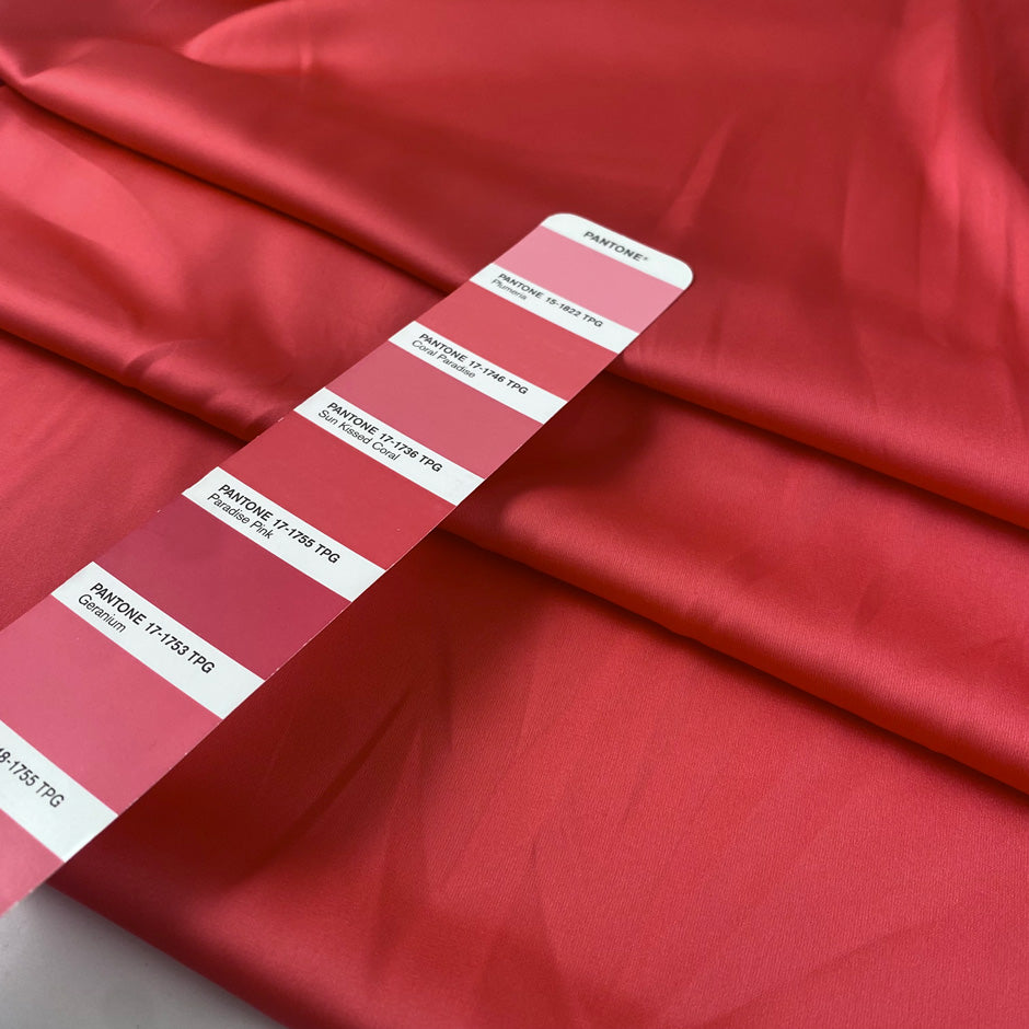 Polyester satin in coral, color reference Paradise Pink. Very soft, light and shiny, not transparent. Ideal for shirting, blouses, dresses and skirts. High-quality deadstock collected in Stock from a Maison de Couture in Italy.