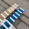 Mixed polyester comfort stretch, with checked design in the shades of beige, color reference natural, and turquoise, color reference fiod blue. A little heavy and flowy, ideal for trousers and jackets. High-quality deadstock collected in Stock from a Maison de Couture in Italy.