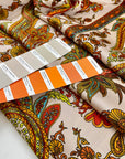 Printed soft polyester twill with small drawings. Orange, beige and bright green floral design. High-quality deadstock fabric collected in Stock from a Maison de Couture in Italy.