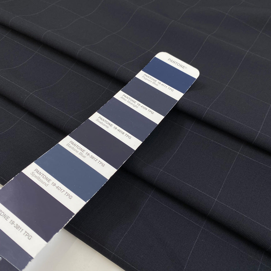 Wool mixed with polyester and elastane featuring a check design in dark blue. Very soft, light, flowy, and not transparent. Ideal for trousers, skirts, and jackets. High-quality deadstock collected in Stock from a Maison de Couture in Italy.