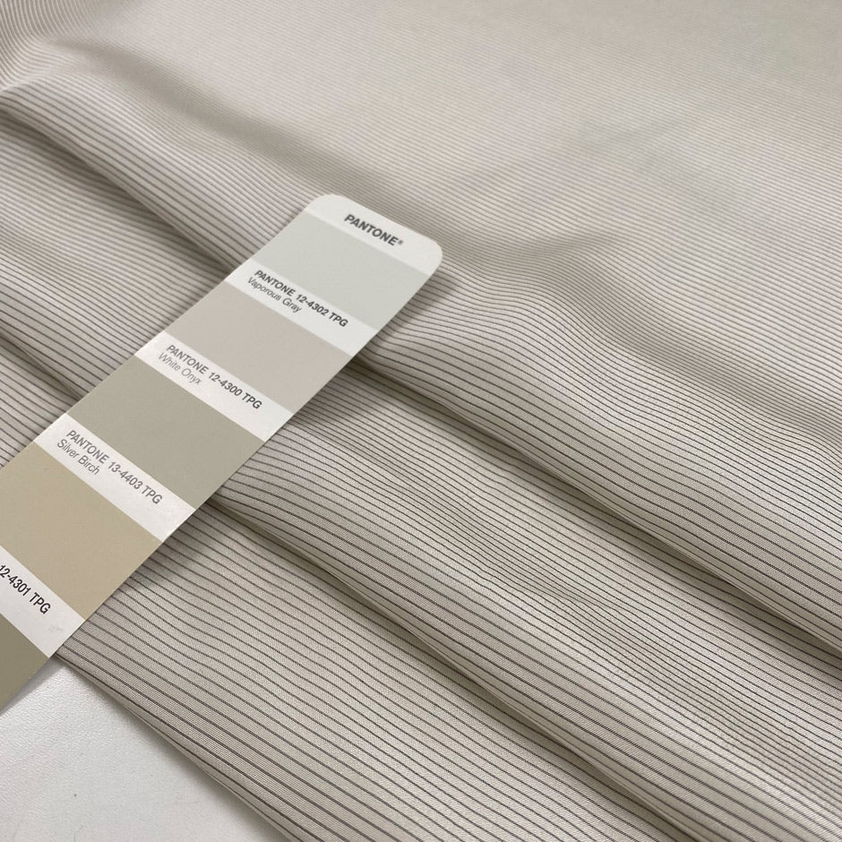 Pure silk crepe de chine with an ivory ground and gray stripes. Very soft and flowy, not transparent. Ideal for dresses, blouses, skirts, and shirting. High-quality deadstock collected in Stock from a Maison de Couture in Italy.