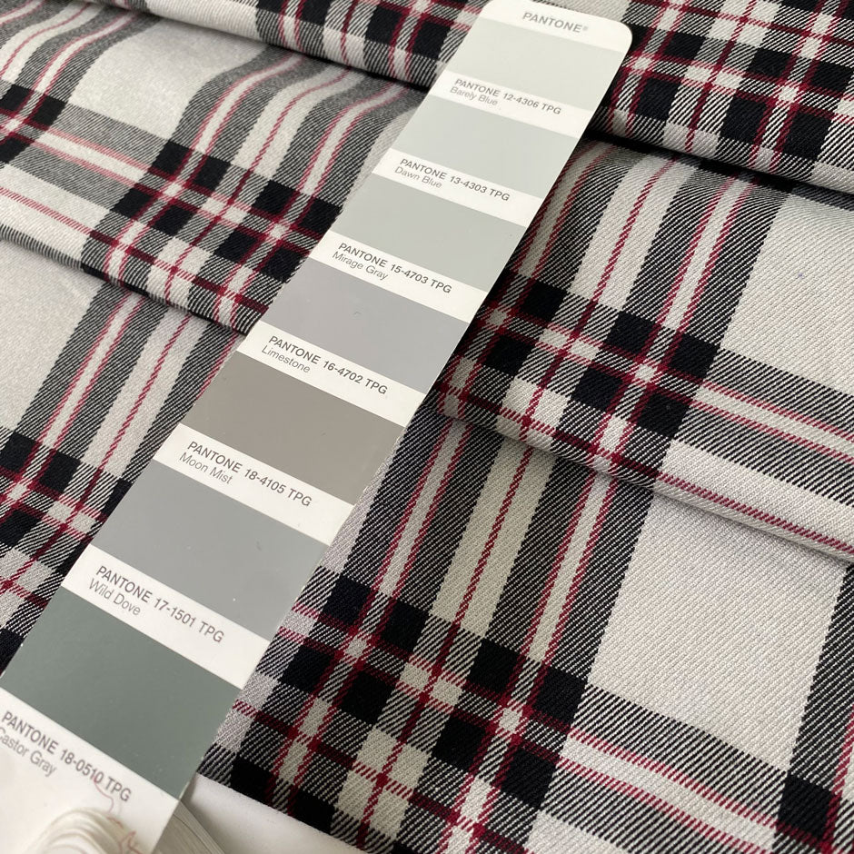 Soft and flowy polyester and viscose fabric with a check design in shades of gray and black, accented by subtle red stripes. Ideal for jackets, trousers, skirts, and dresses. High-quality deadstock collected in Stock from a Maison de Couture in Italy.